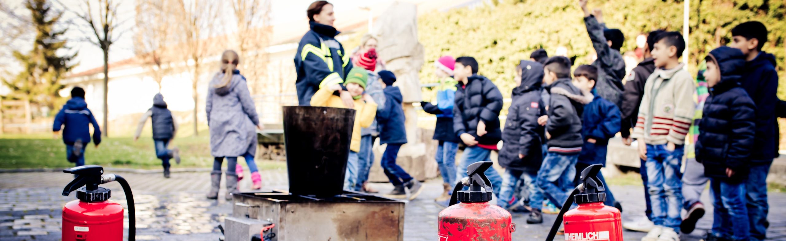 Eine Frau von der Feuerwehr erklärt Kindern Feuerlöscher_Lernen durch Engagement in Sachsen-Anhalt_Foto Anne Hornemann